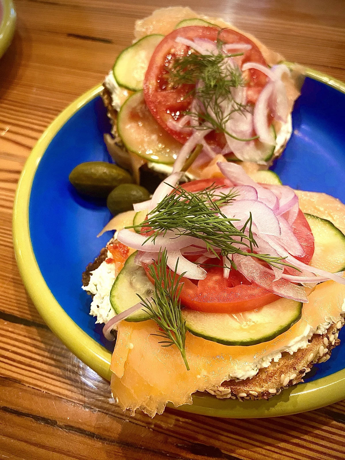 open-face bagel w/ lox, cream cheese, tomato, cucumber, red onion, dill, capers on a bl…